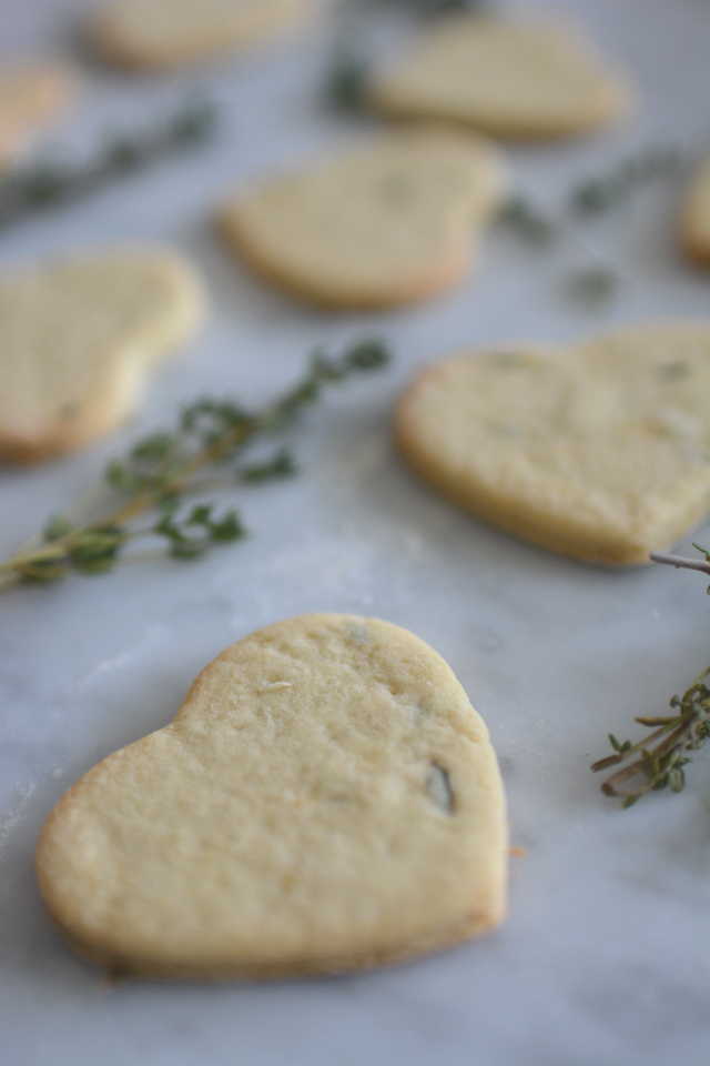 close-up image of heart-shaped Lemon Thyme and Mint Cookies, freshly baked and adorned with delicate thyme leaves