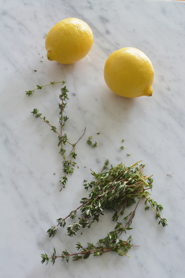 overhead view of two fresh lemons and a bunch of thyme leaves