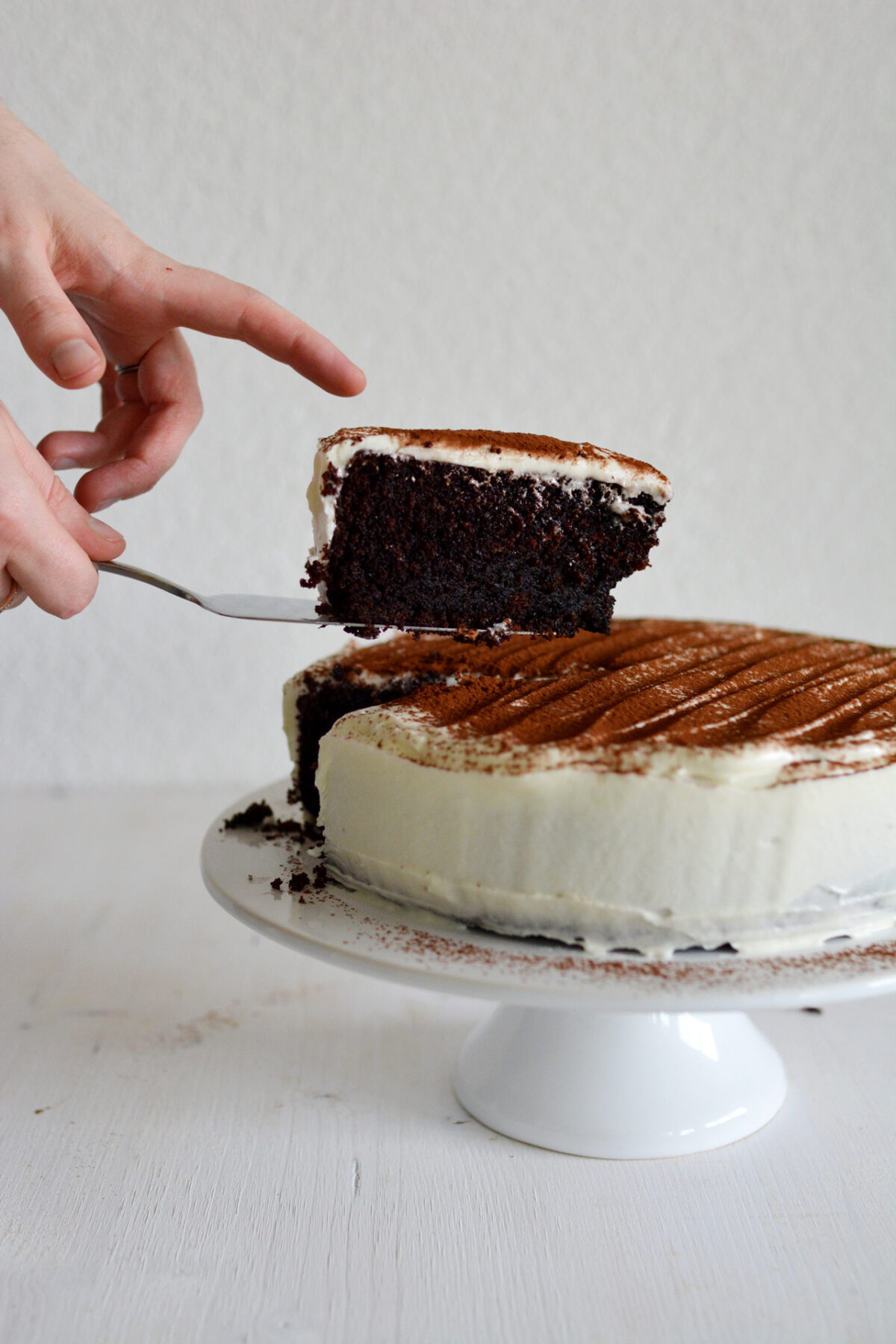close-up image of a cake being delicately sliced, with the slices being lifted by a hand using a cake slicer