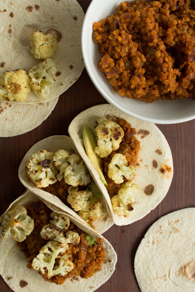 tacos filled with roasted cauliflower, spicy lentils, sultanas and avocado
