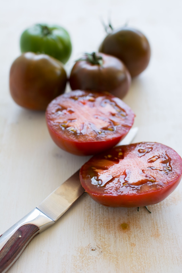 close up image of fresh cherry tomatoes one is cut in half
