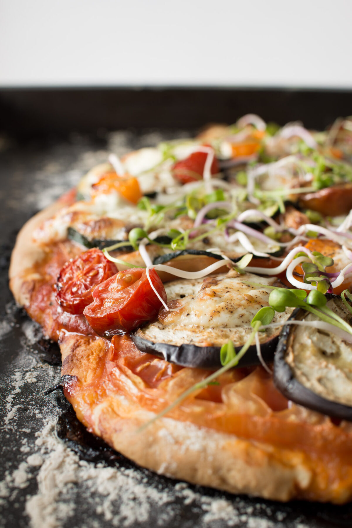 close-up view of a Mediterranean No-Rise Scone-Based Pizza with creamy burrata, accentuated by fresh sprouts on top