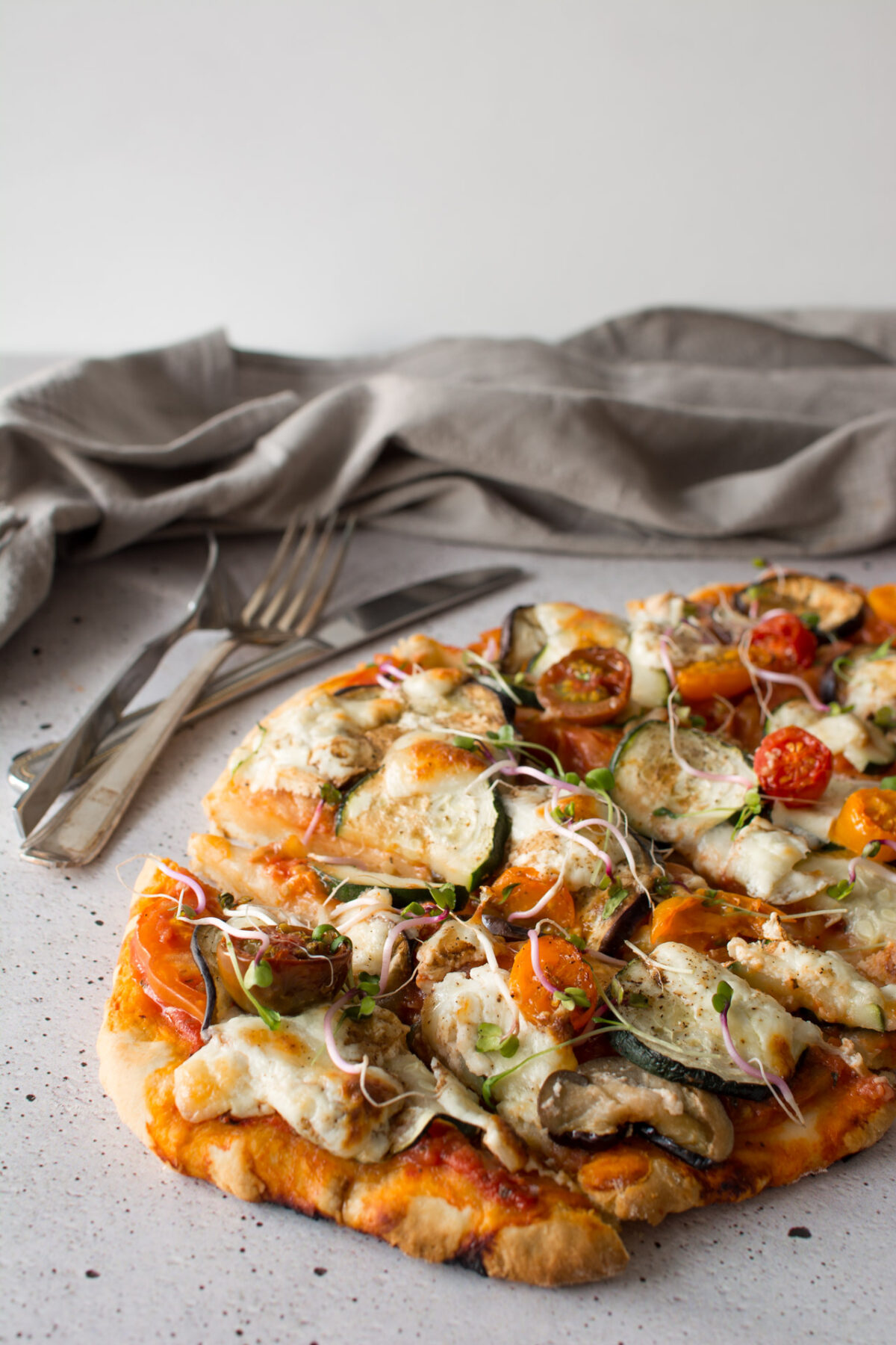 half image of mediterranean no rise scone based pizza with burrata topped with fresh sprouts