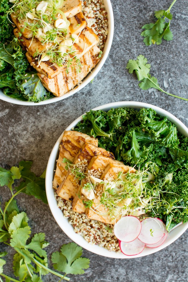 top view image of two bowls full of delicious teriyaki tofu topped with kale, nuts and sesame seeds