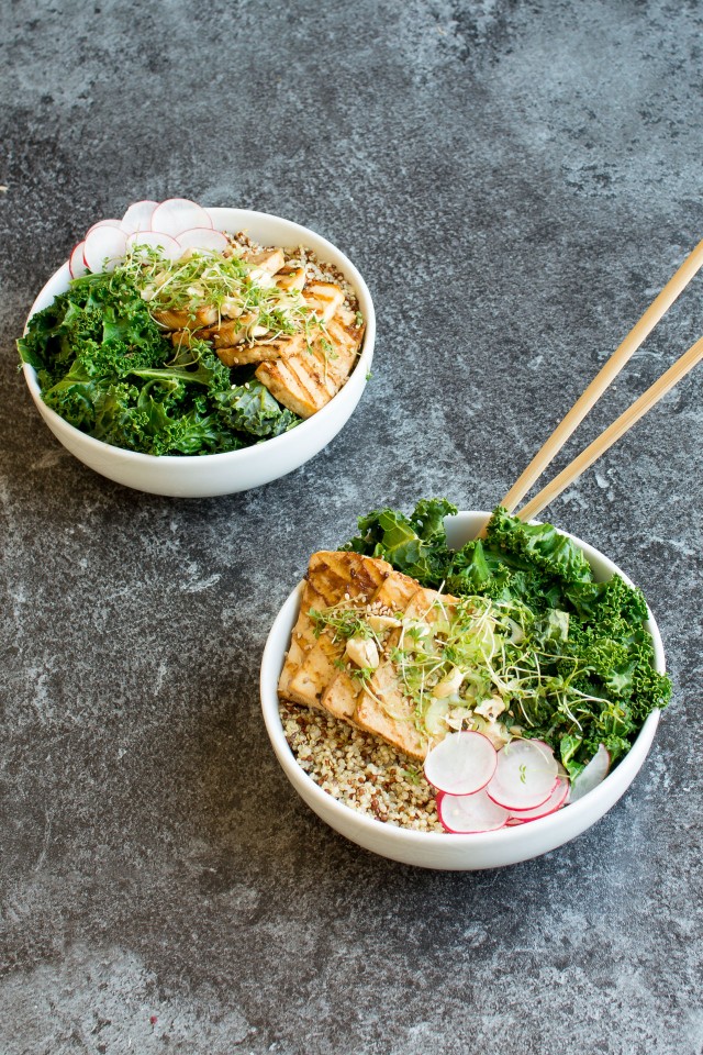 top view image of two bowls full of delicious teriyaki tofu topped with kale, nuts and sesame seeds, with chopsticks