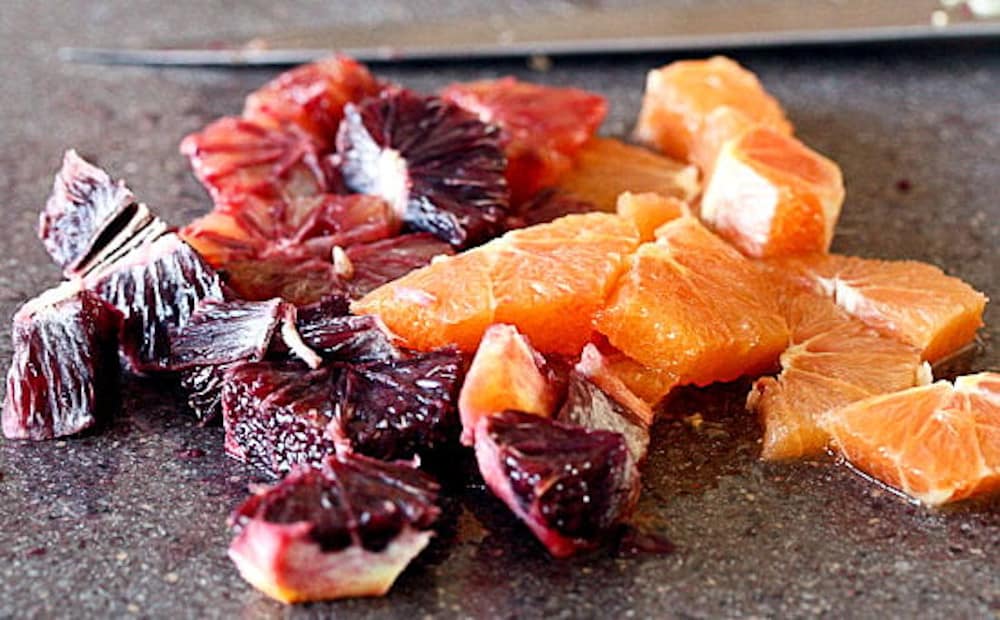 Moro blood orange and Cara Cara orange cut up on a countertop.